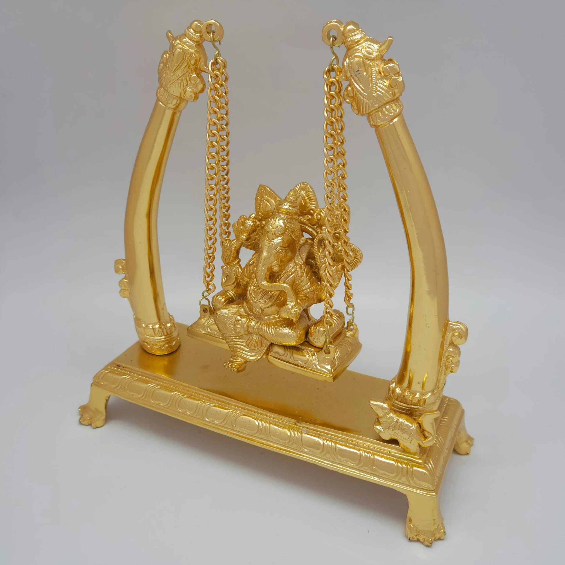 Three-quarter left angle view of the anti-tarnish premium brass Vinayagar oonjal sculpture highlighting the depth of the wide rectangular pedestal base