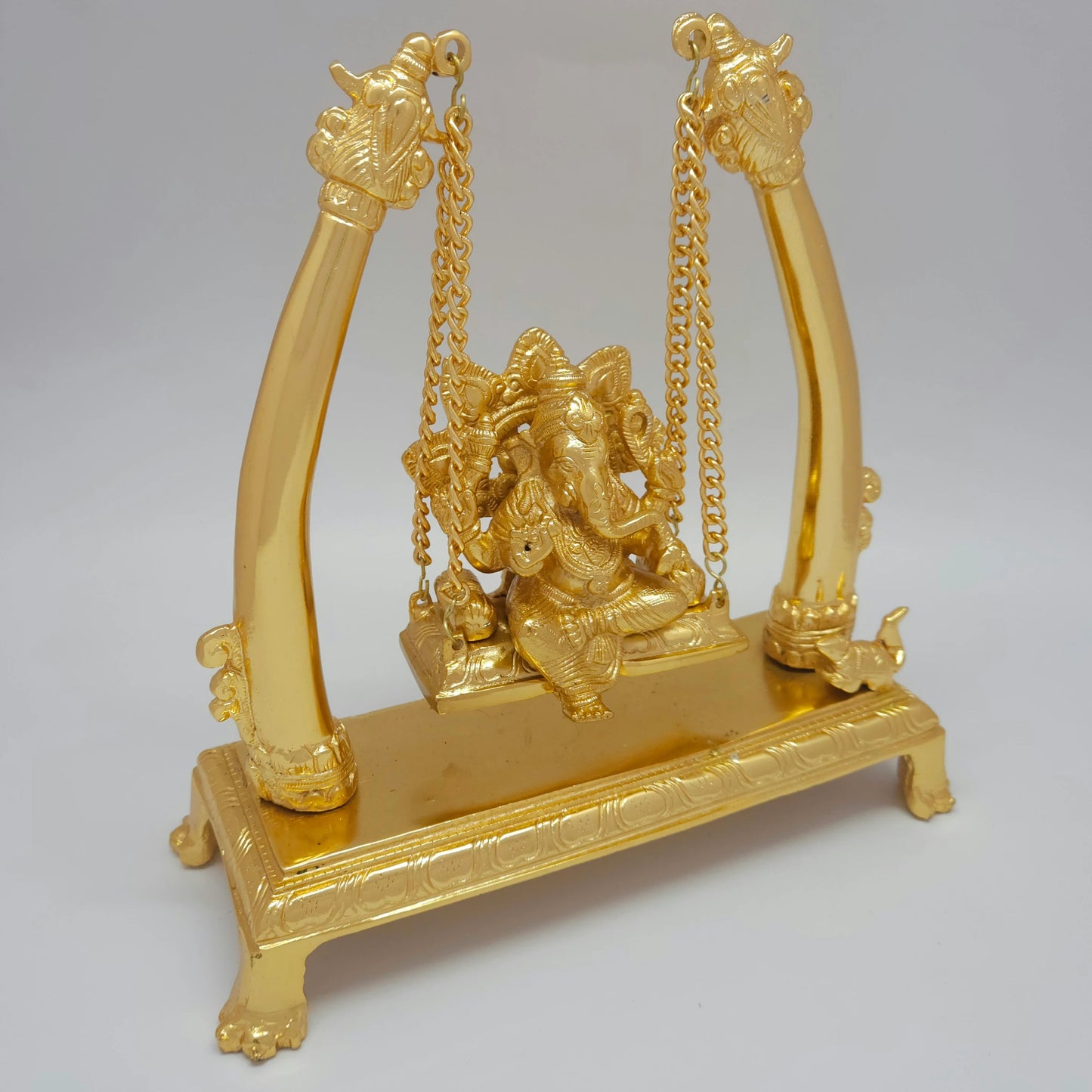 Three-quarter right perspective of the gold-colored powder-coated brass swinging Ganesha idol showing the elegant curve of the mirror-polished royal pillars