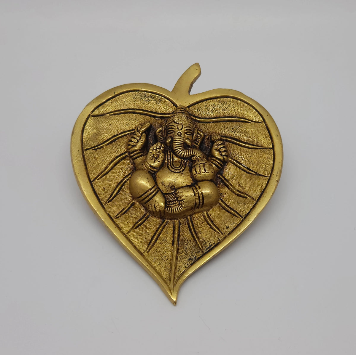  Front straight view of the 5.3 inch premium solid brass Ganesha on betel leaf wall hanging from Sri Swaminathan and Co stock showing the detailed antique finish layout.