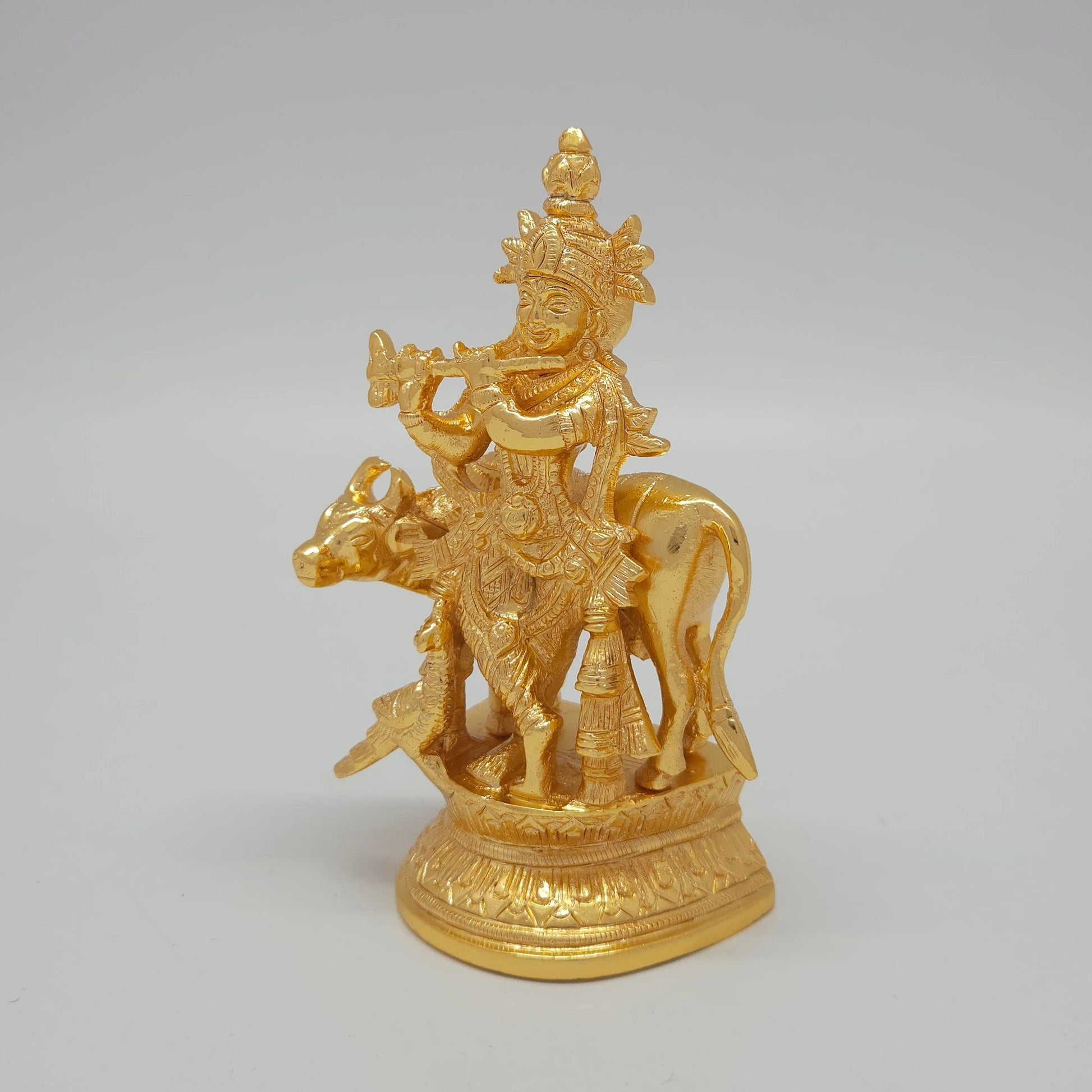 Premium Brass Lord Krishna statue 13cm 45 degree front right corner view focusing on kamadhenu cow face