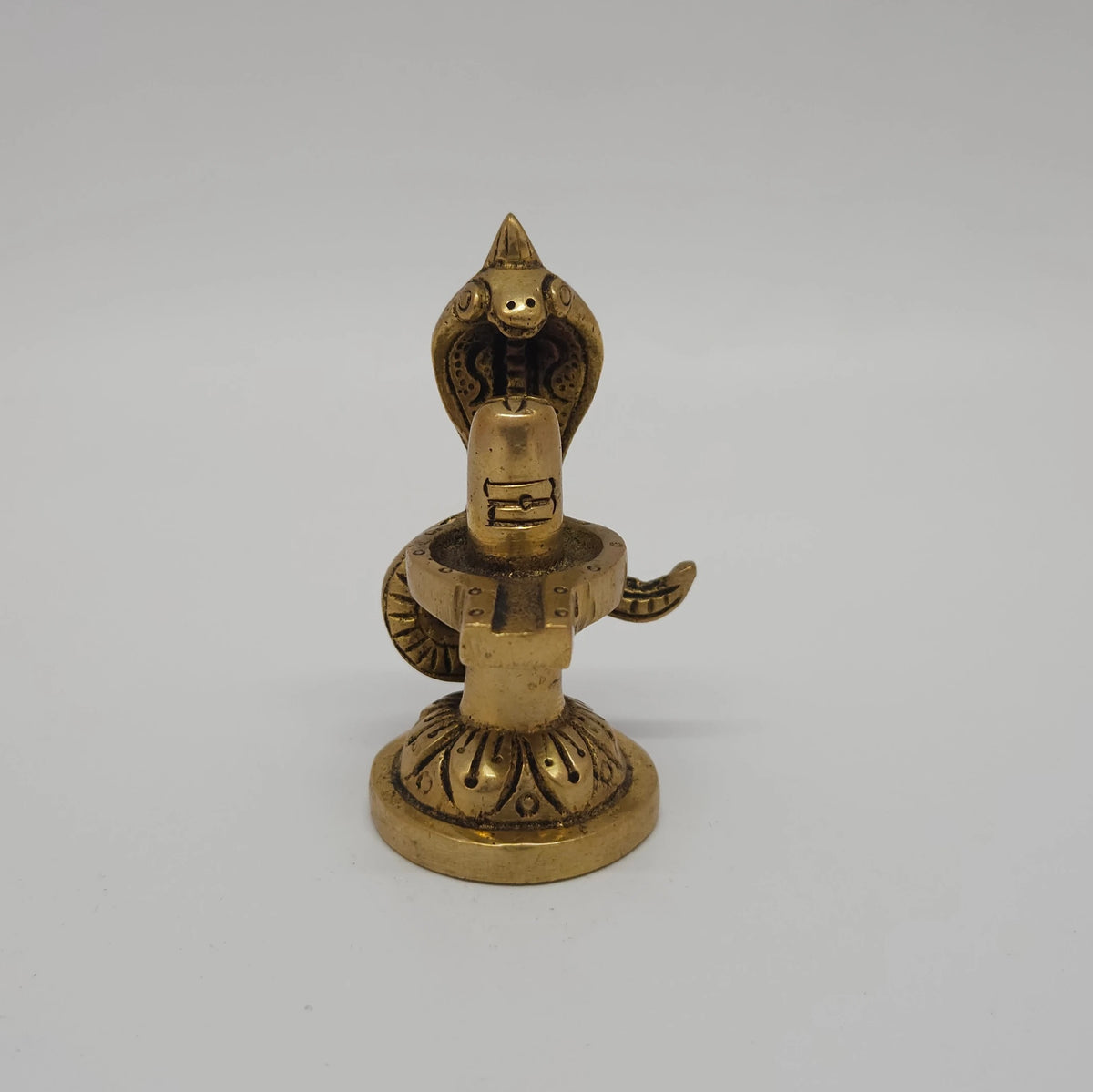 Front straight profile view of the 2.7 inch premium solid brass Nagalingam Sarpa Lingam statue under a five-headed snake canopy showing the Tripundra markings and lotus pedestal from Sri Swaminathan and Co stock.
