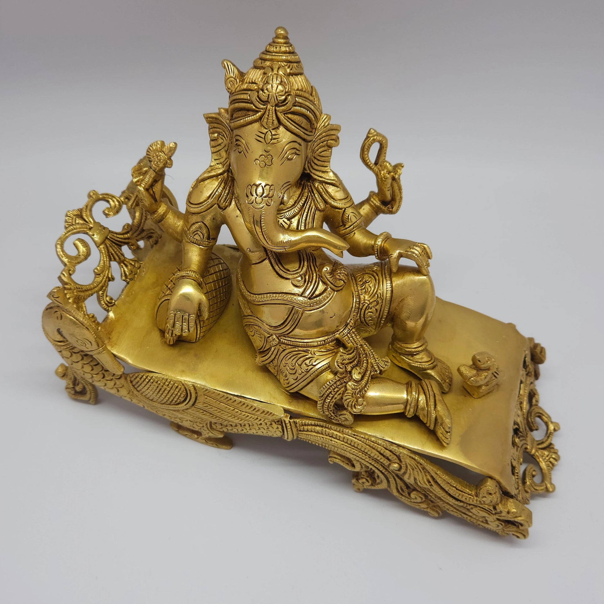 Premium Antique Brass reclining Ganesha statue 27cm length side view focusing on bolster cushion pillow and right arm placement