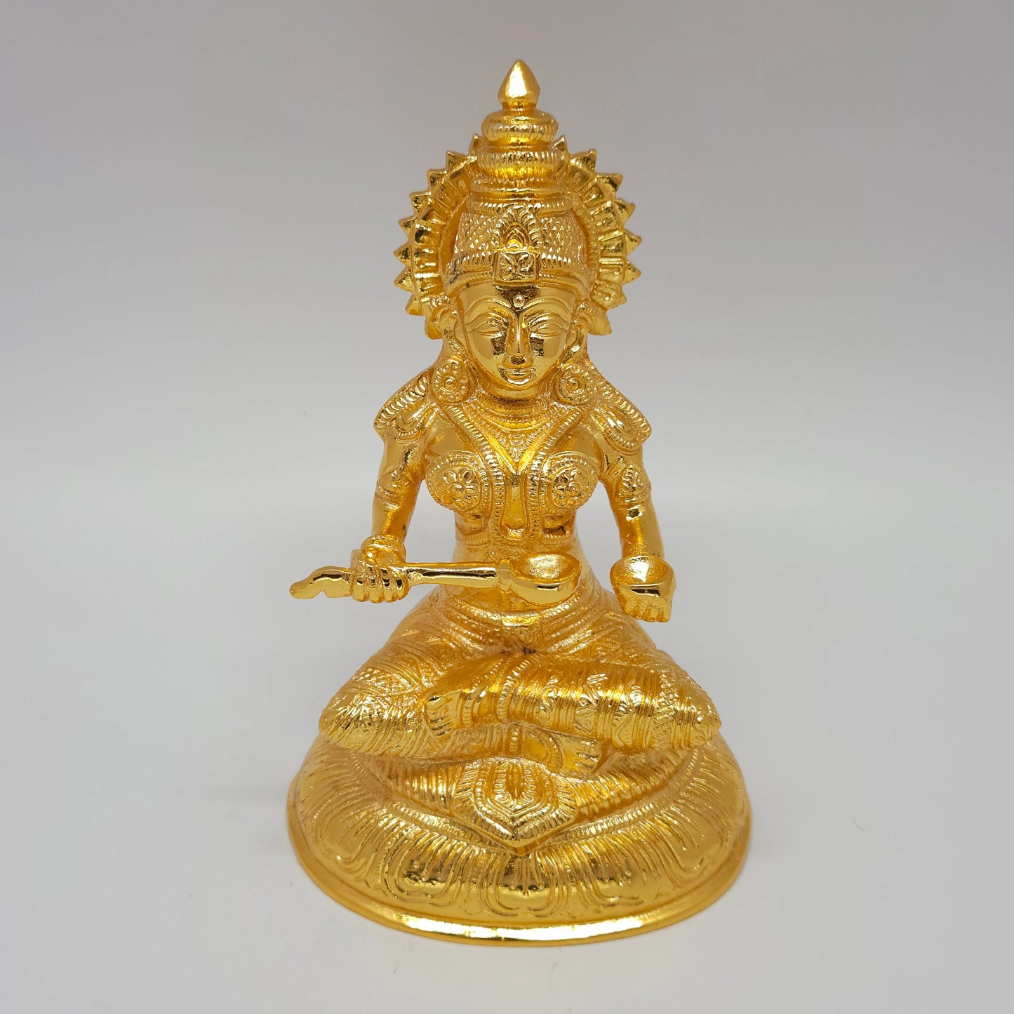 Premium Brass seated Goddess Annapoorani statue 7-inch 19cm height ariel view showing sunburst sirachakra halo and circular base including laddle and bowl