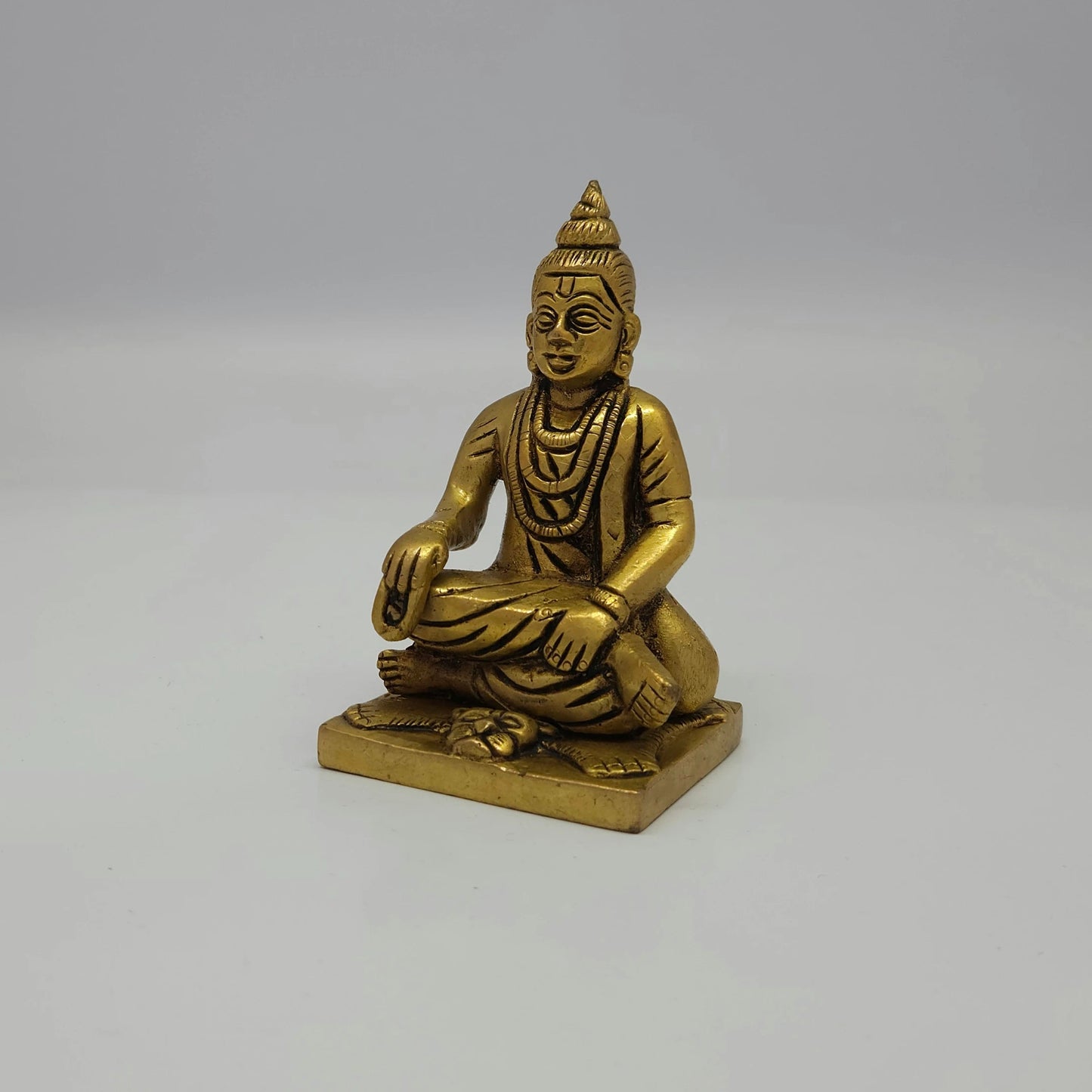 Premium Brass seated Sripada Srivallabha statue 4-inch 10cm 45-degree front right corner view focusing on rudraksha malas and base details