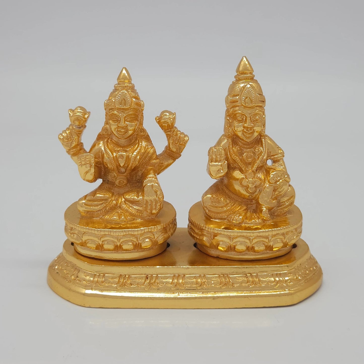 Front view of the 9cm premium gold powder-coated brass Kubera Lakshmi showpiece on a shared base platform for corporate office decoration.