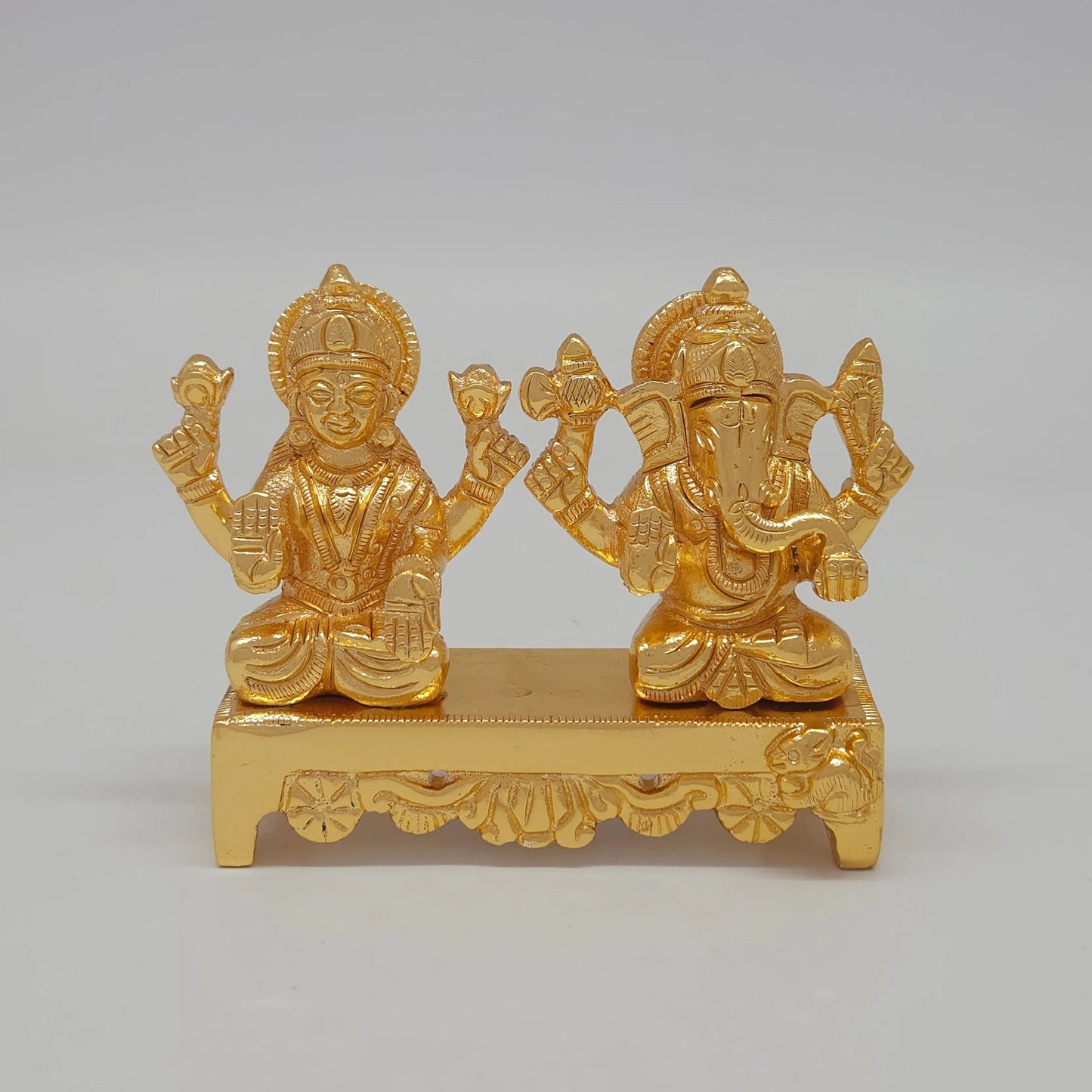 Front view of the 7.5cm premium gold powder-coated brass Laxmi Ganesha on a bench desk showpiece for corporate gifting.