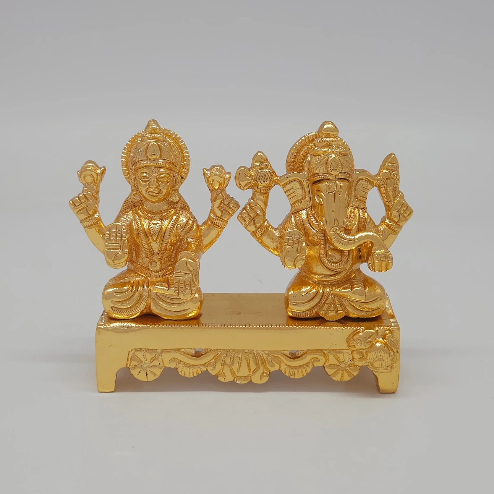 Front view of the 7.5cm premium gold powder-coated brass Laxmi Ganesha on a bench desk showpiece for corporate gifting.