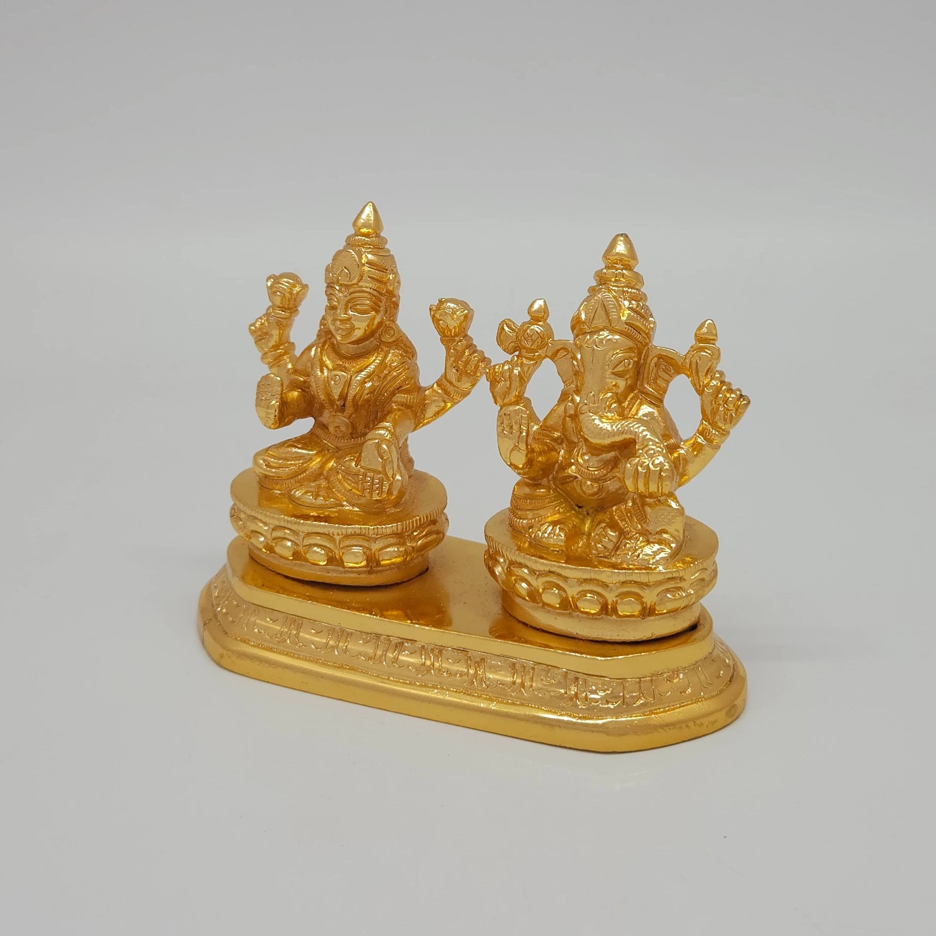 Left 45-degree angle profile emphasizing Goddess Lakshmi's lotus details, Ganesha's side posture, and the ornate tiered base borders.