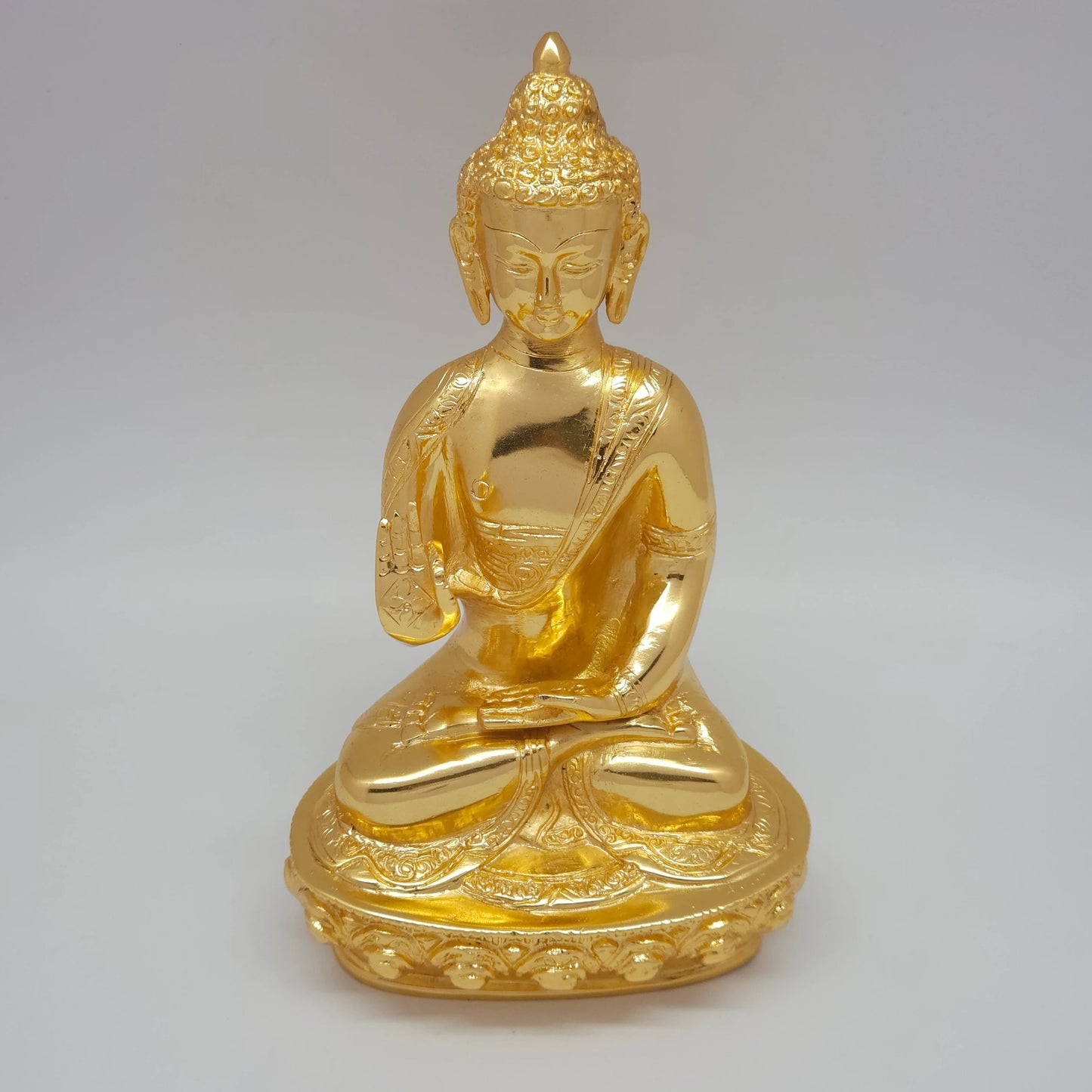 Ariel angle profile of the glossy gold powder-coated Buddha brass figurine highlighting the raised blessing hand