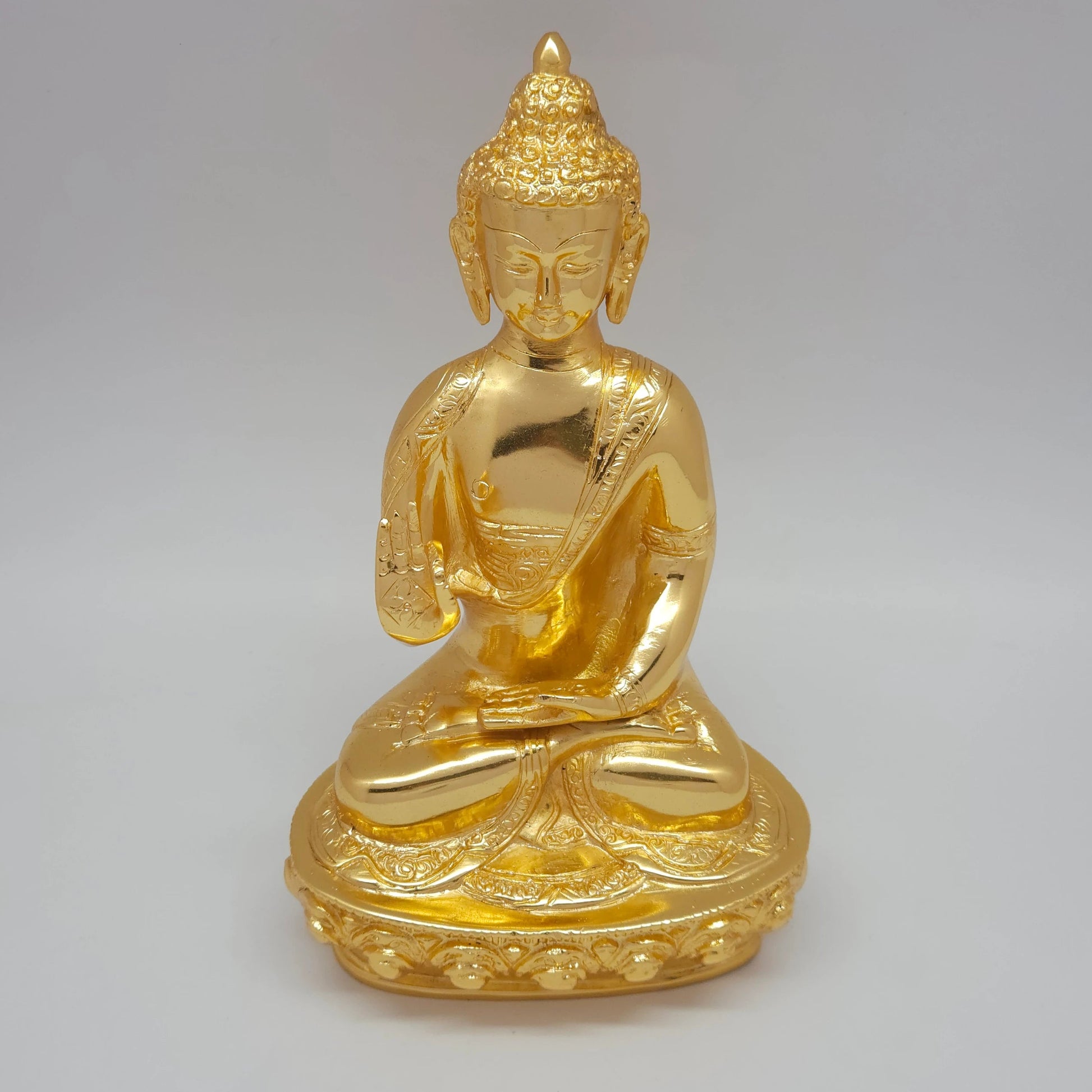 Ariel angle profile of the glossy gold powder-coated Buddha brass figurine highlighting the raised blessing hand