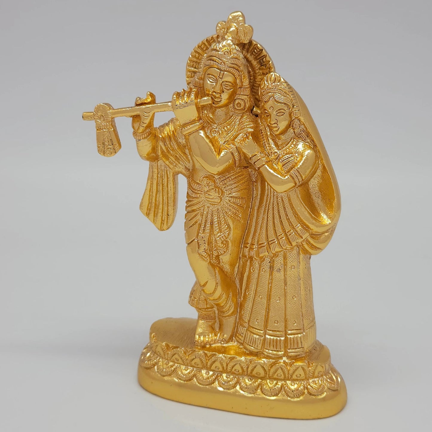 Left 45-degree angle profile emphasizing Krishna's cross-legged stance, flute alignment, and the ornate tiered base borders