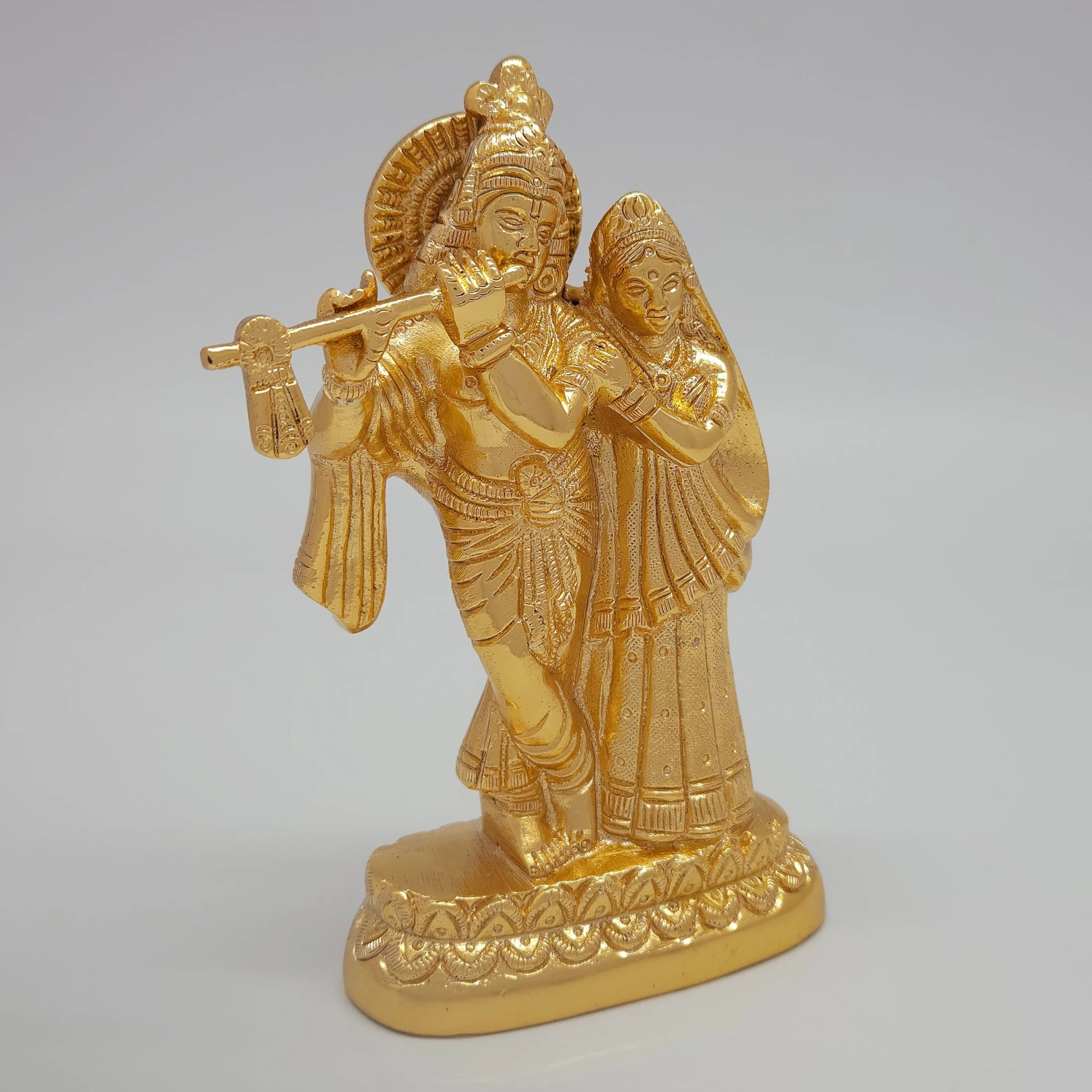 Right 45-degree perspective highlighting Radha's profile features, her gown texture, and the polished metal side boundaries
