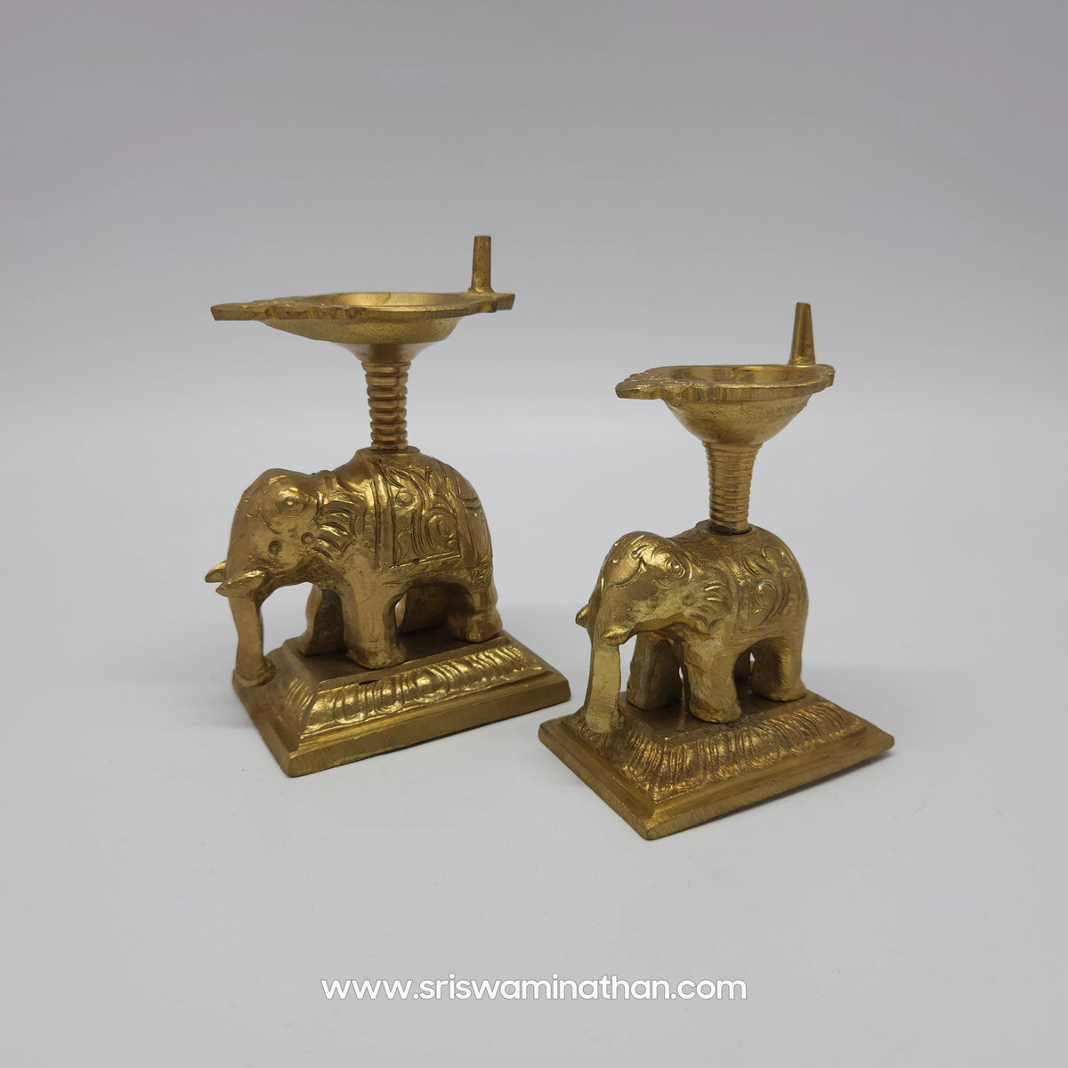 Side by side size comparison view of two handcrafted pure brass elephant diya lamps showcasing both variant options together.