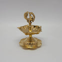 A single brass peacock lamp with five wicks and stable floral base.