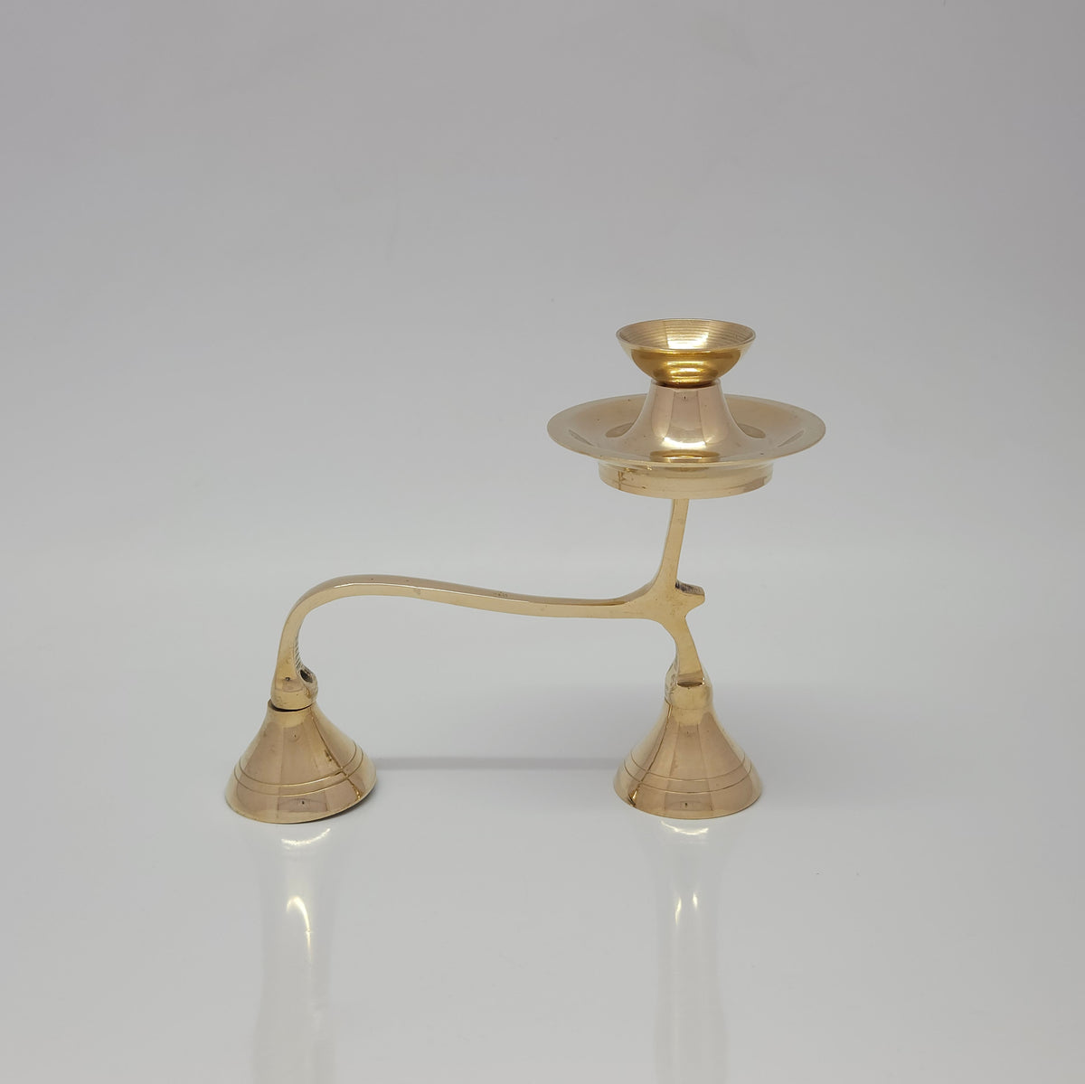 Side view of the solid brass two-tier camphor aarti holder showing the arching handle and wide cone-shaped supportive feet.