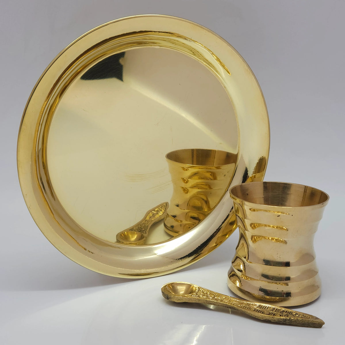 Traditional brass thali layout paired with a pure brass tumbler and spoon to create an Ayurvedic royal dining presentation.