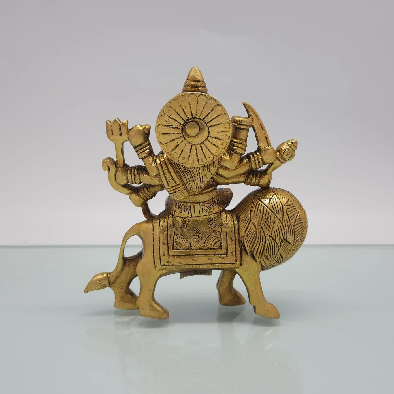 Rear view showcasing the solid back structure of the circular crown halo, the lion's flanks, and the raw antique brass texture of the 1.1kg idol