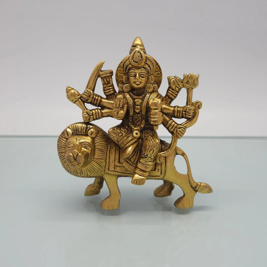 Front view of the 14.5cm antique solid brass Ashtabhuja Durga statue riding her lion with eight arms holding weapons for Navaratri pooja.