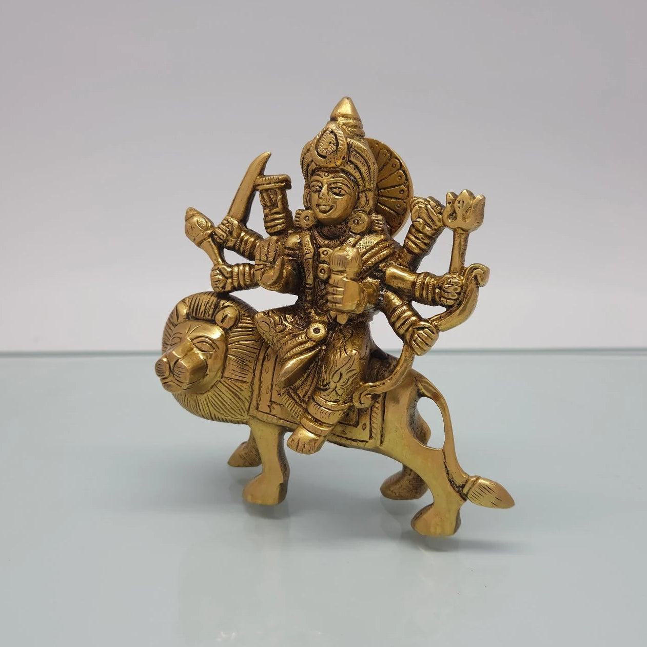 Left 45-degree angle profile emphasizing the detailed sword and mace weapons held in the left hands, and the lion's forward mane.
