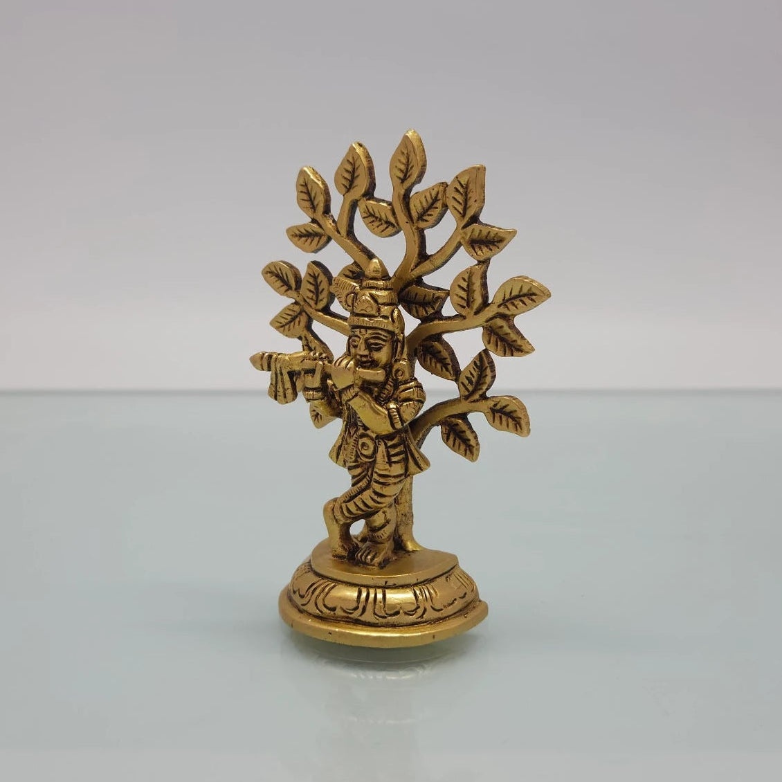 Left 45-degree angle profile emphasizing Krishna's three-bend body posture, the flute length, and the rounded base outlines