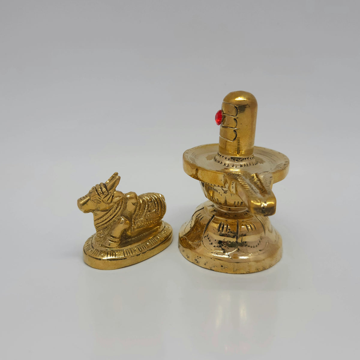Three-quarter front right perspective view of the 3.5 inch solid brass Shivalingam and 2 inch Nandi bull demonstrating base thickness