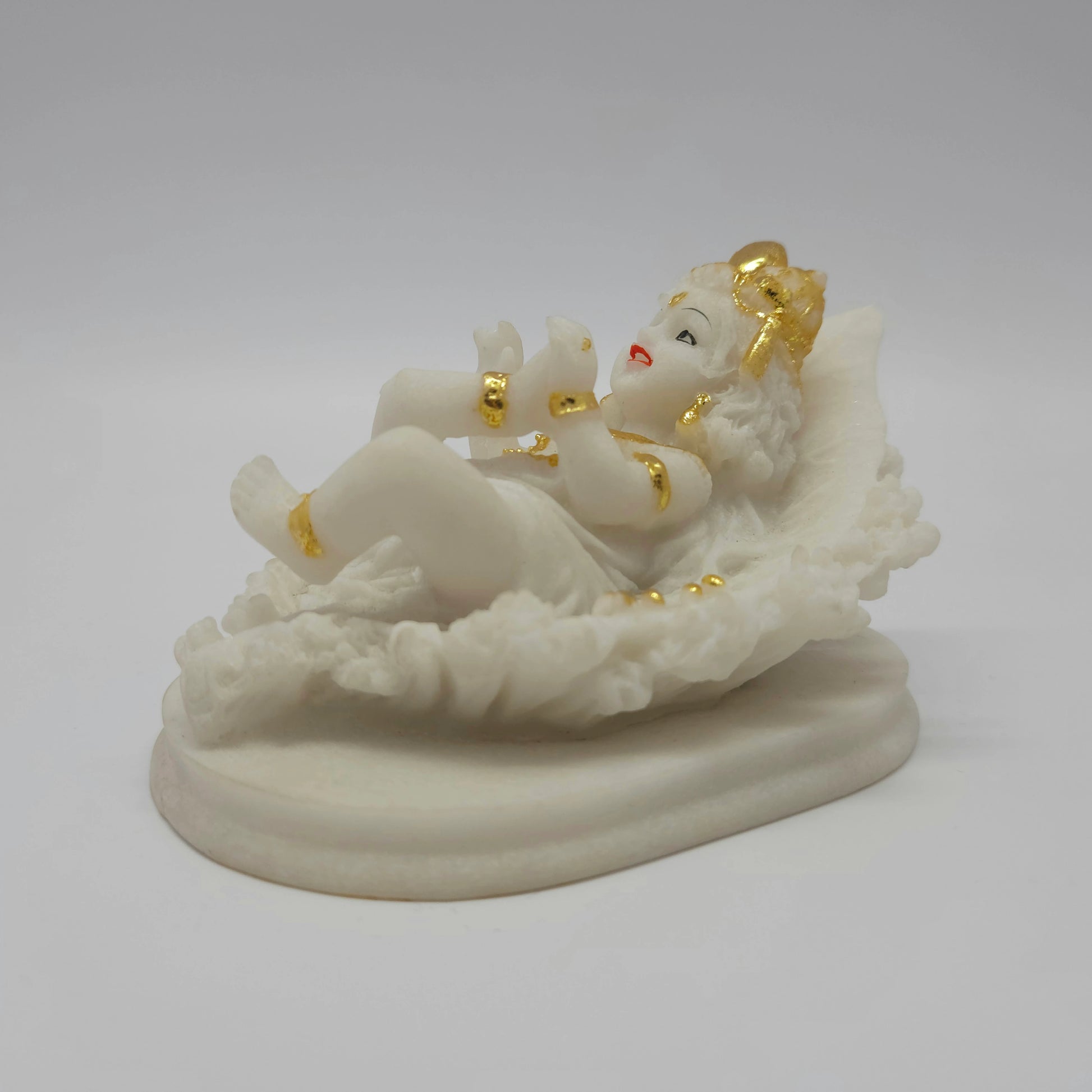 Front right perspective of the 3-inch baby Krishna statue demonstrating the clean details of the leaf veins and the solid pedestal.