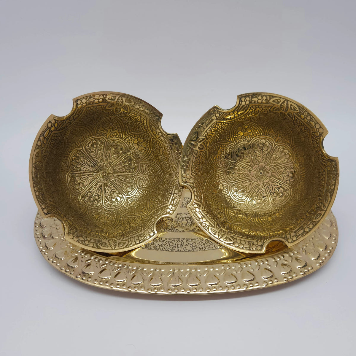High angle top-down view displaying two 4.9 inch floral engraved brass bowls arranged symmetrically on a tray to practically demonstrate interior design variations