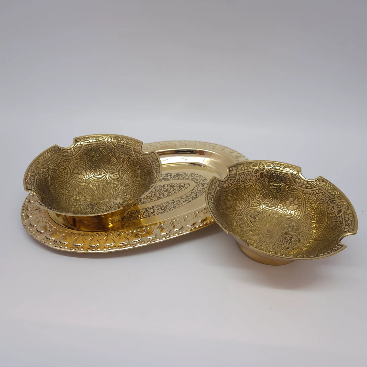 Distant low angle view displaying one 4.9 inch scalloped brass bowl on an engraved tray next to a separate bowl to practically explain individual piece layout choices.