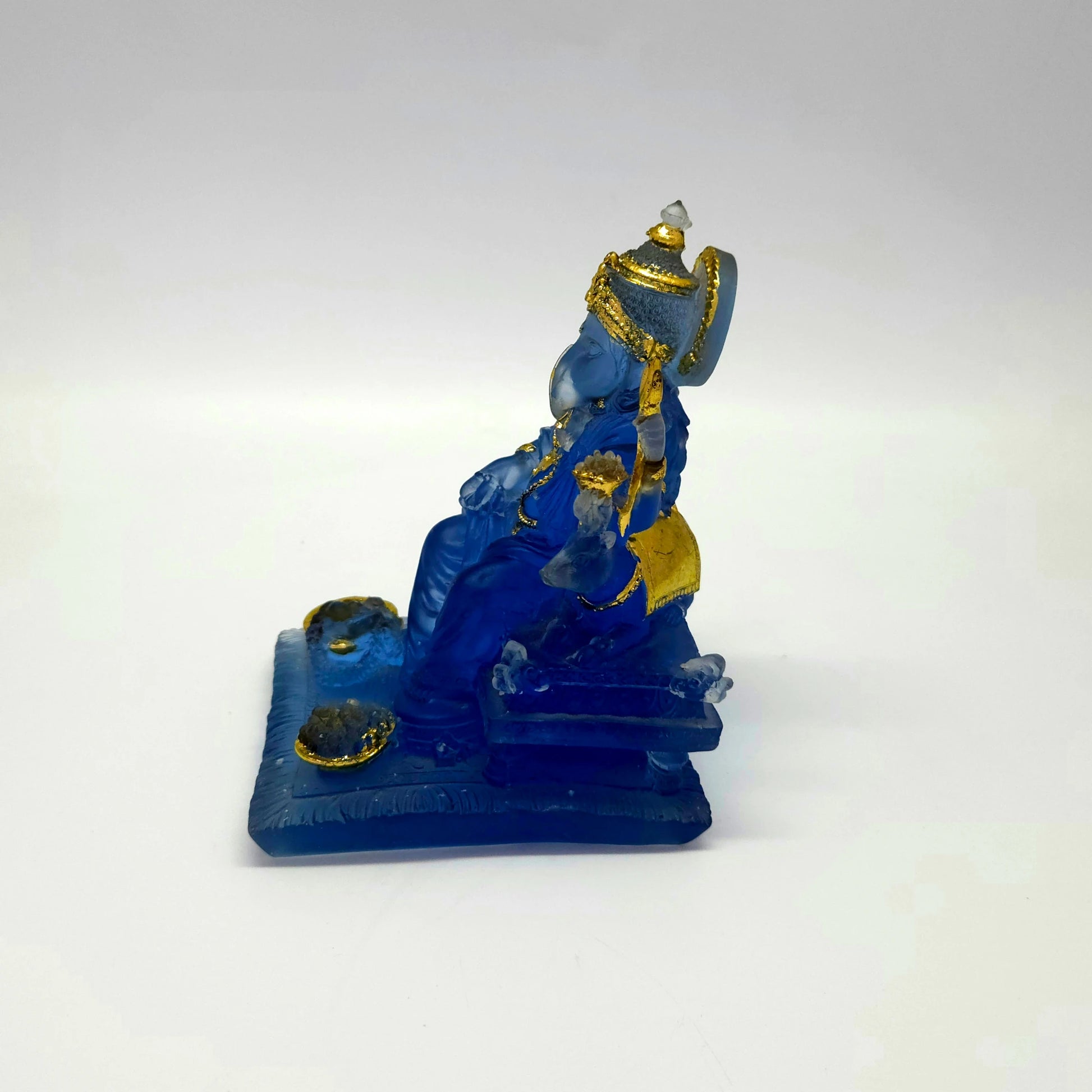 Right side profile of the 5.1 inch frosted blue resin Ganesha figurine showcasing his crown height and sturdy throne layout.