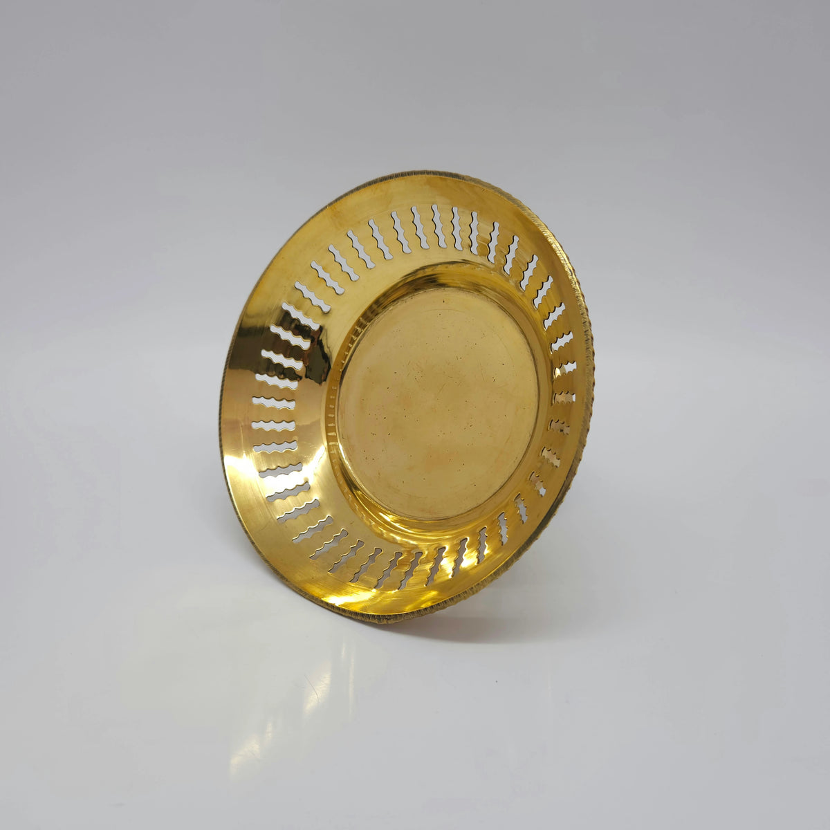 Tilted top-down perspective view looking inside the 6 inch lattice cutwork brass fruit bowl showcasing the smooth flat interior base basin.