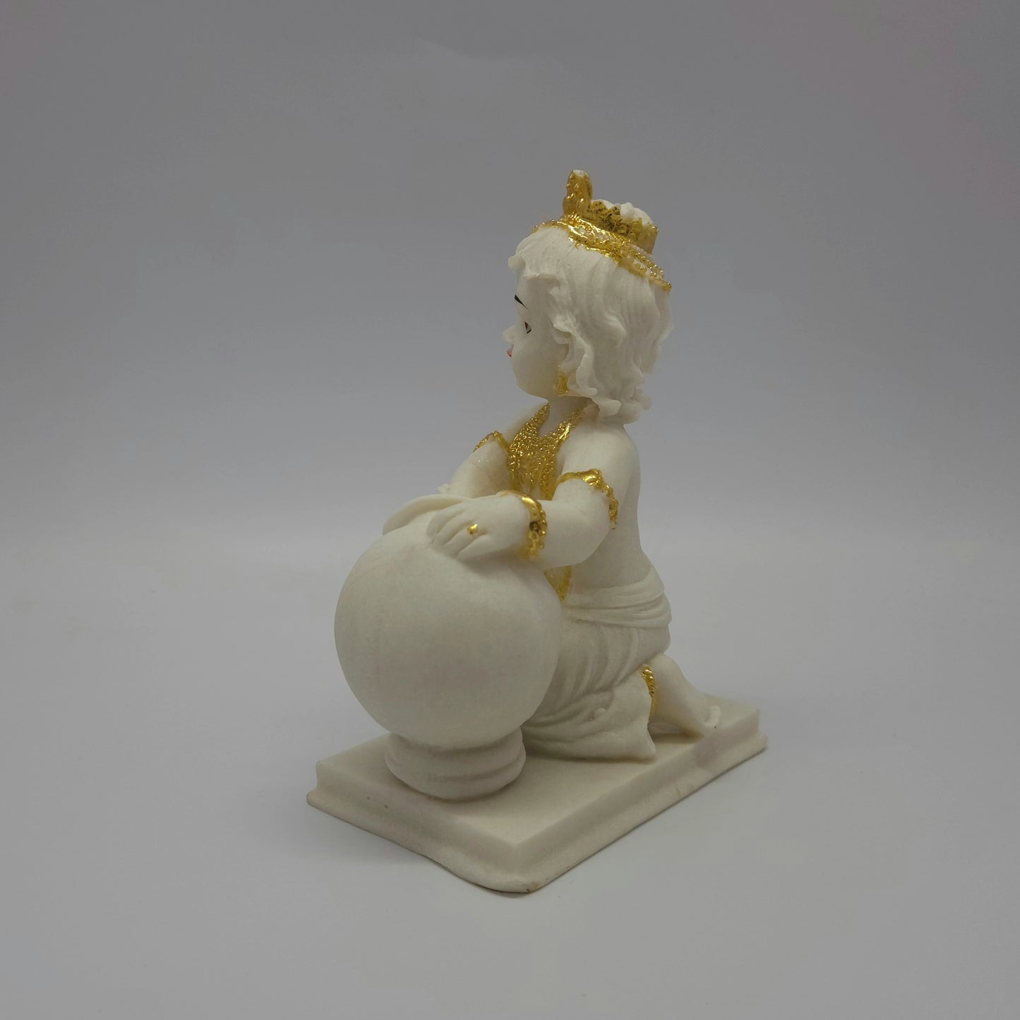 Right profile image of the 7.1 inch baby Krishna statue demonstrating the clean contours of the round clay pot and the rectangular base plate.