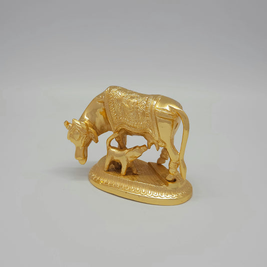 Three-quarter perspective view of the anti-tarnish gold powder-coated brass holy Gomatha cow figurine highlighting the detailed textures on the calf.