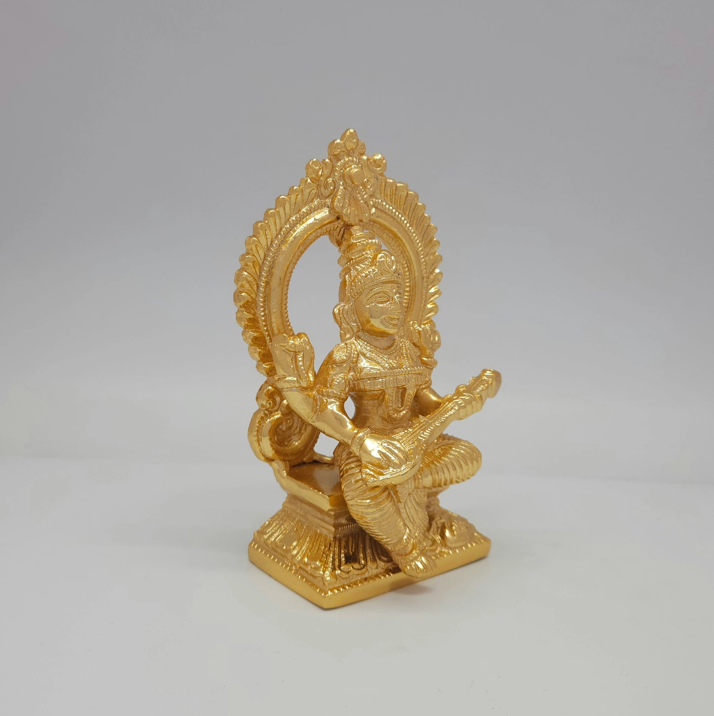 Right side profile of the 5.7 inch gold-colored brass Goddess of Education figurine displaying the elegant thickness of the Prabhavali frame.