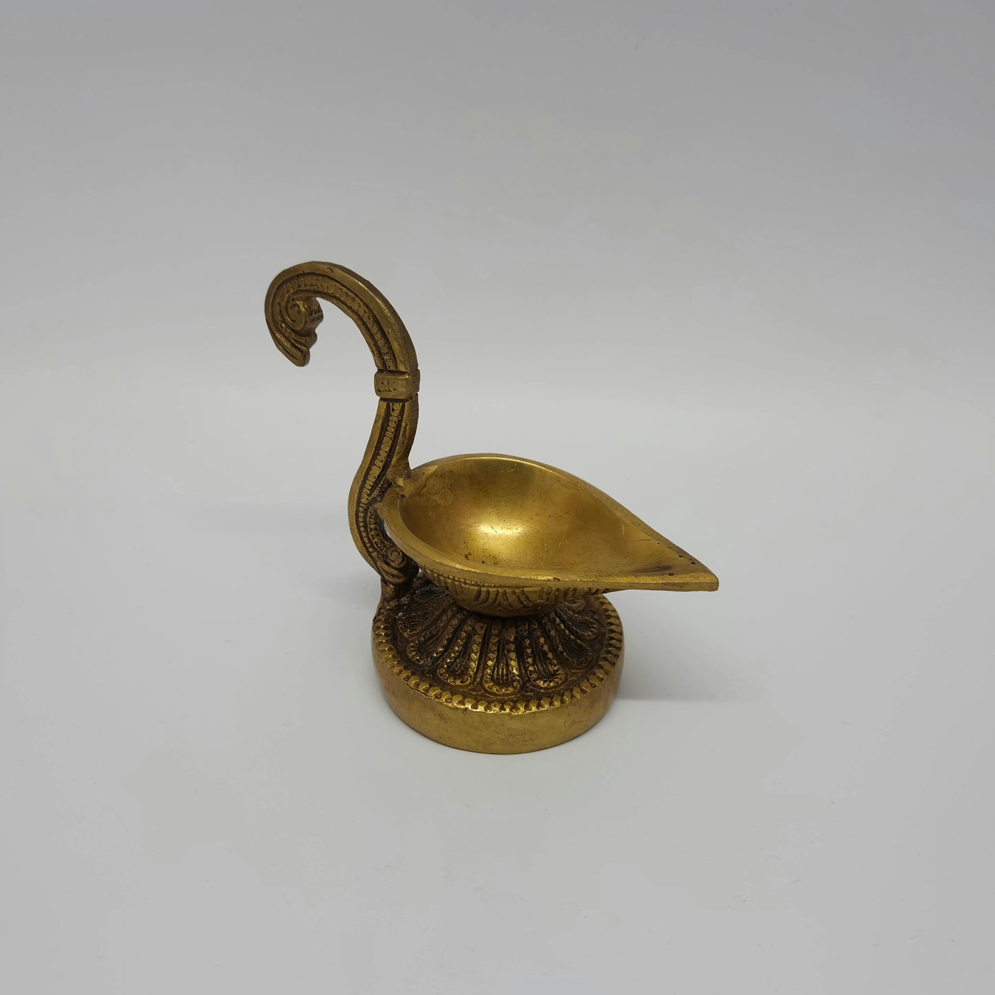 Three-quarter high angle view of the 480g heavy brass handheld oil lamp showing the inside of the 5cm wide single wick oil basin.