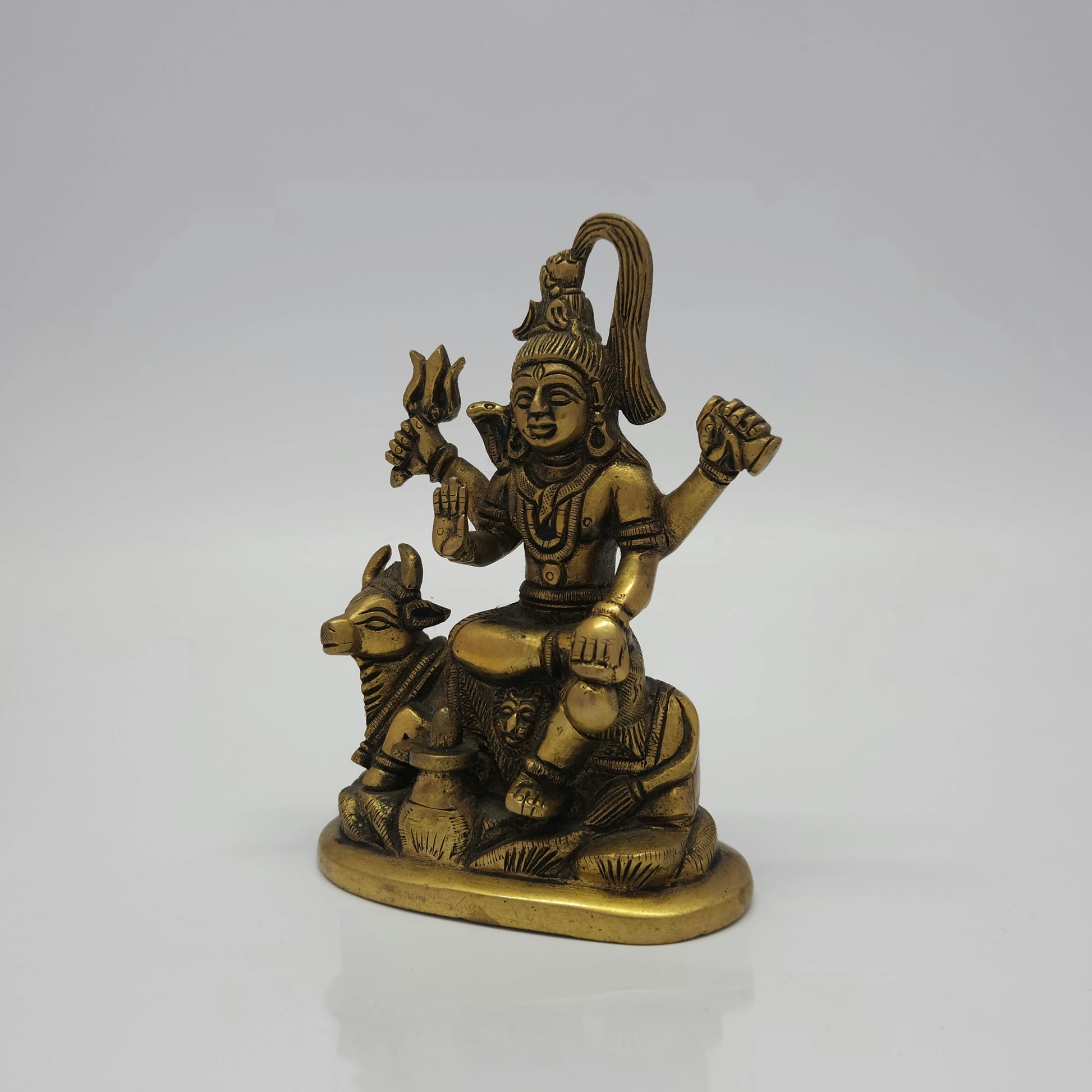 Three-quarter left angle view of the antique-finished brass Lord Shiva idol highlighting the detailed placement of the front Shiva Lingam