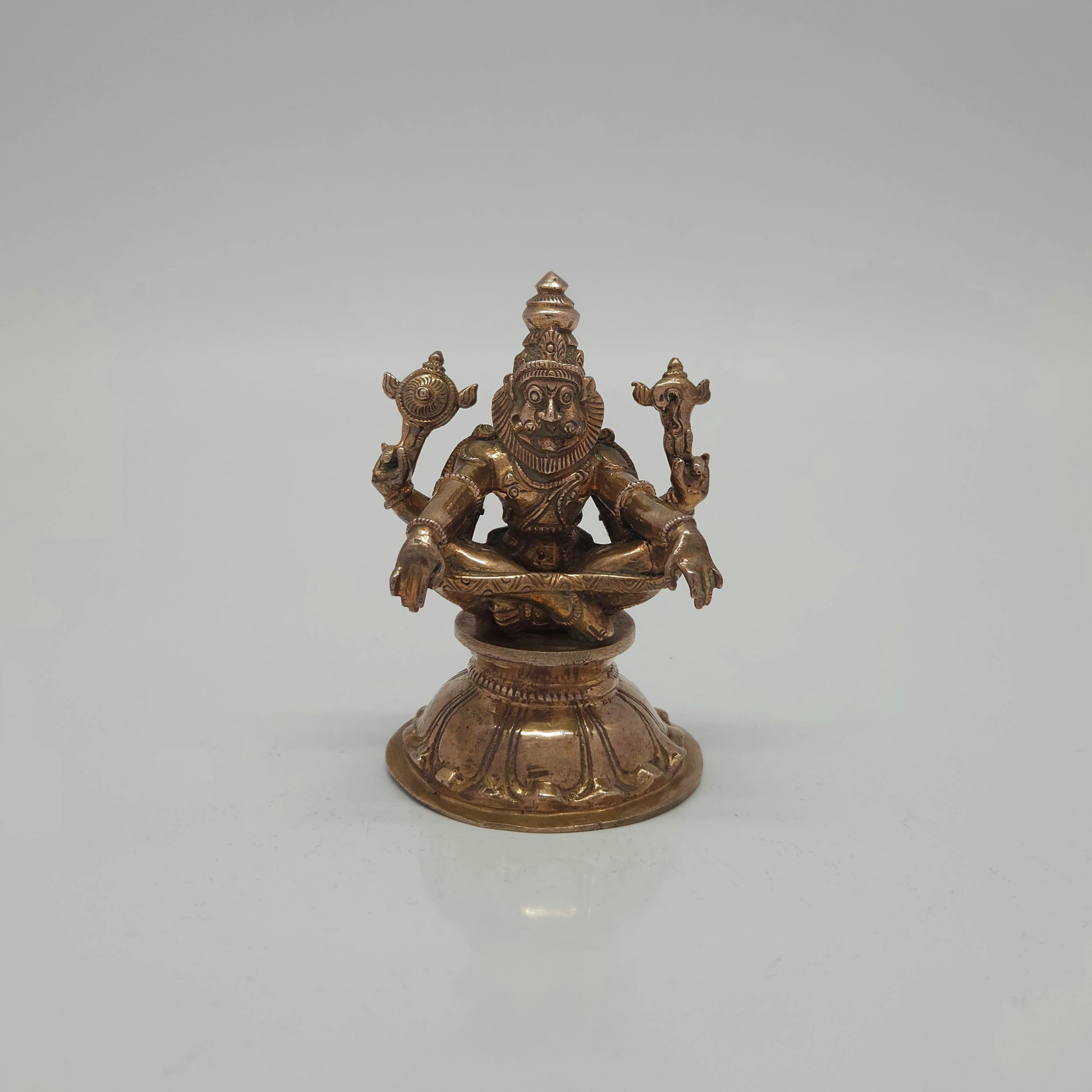 Straight front view of a 9.5cm unique handmade solid cast raw Kumbakonam Panchaloha Lord Yoga Narasimha Swamy statue on a lotus pedestal by Sri Swaminathan and Co.
