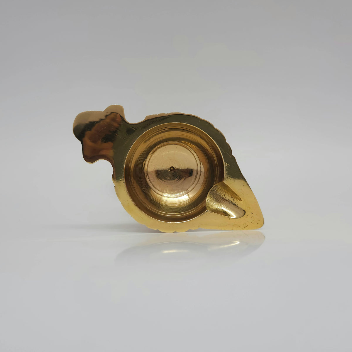 High angle top-down view looking directly into the single-spout oil basin highlighting the flat brass tab handle and the 20ml capacity reservoir.