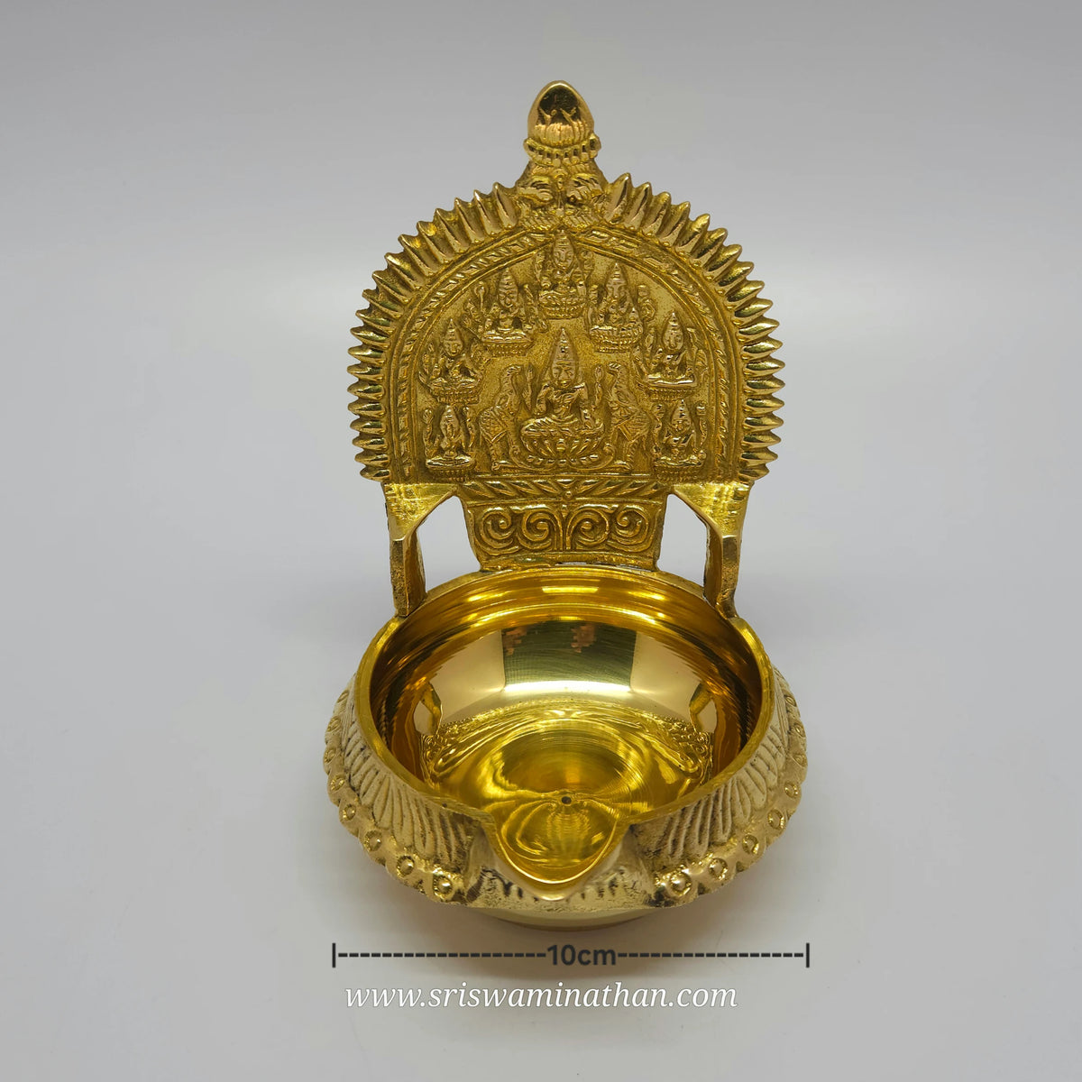 Straight front view of the 14cm brass Ashtalakshmi Kubera Nalla Vilakku showcasing the centered Gajalakshmi surrounded by seven forms of Lakshmi with length measurement marker by Sri Swaminathan and Co.