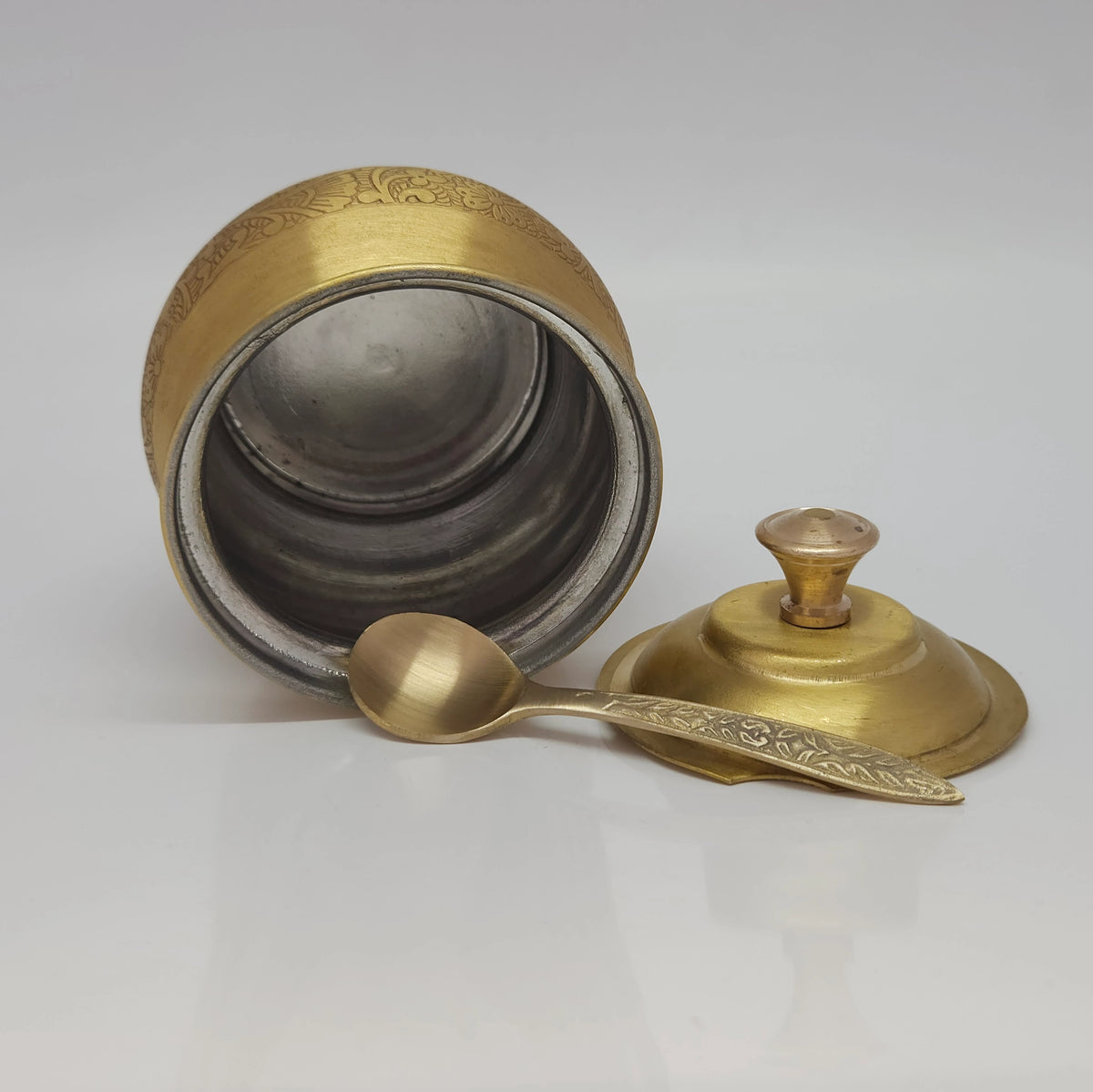 Three-quarter alternative side view of the matte engraved brass ghee pot set illustrating the smooth contours of the body and rounded lid knob