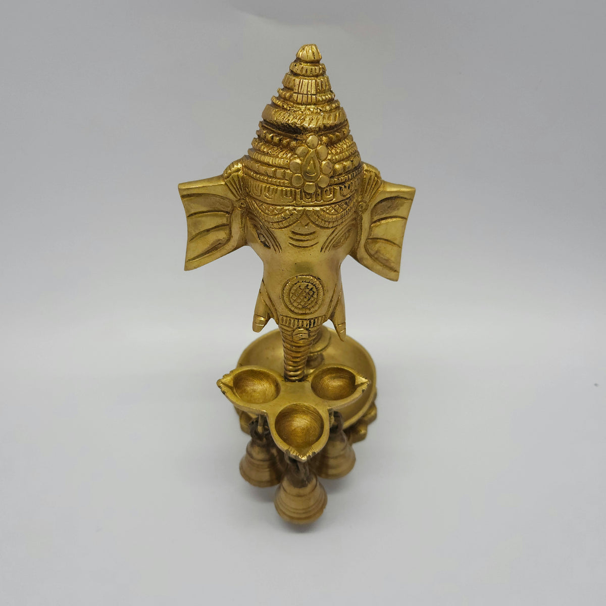 High 45-degree angle top down view of the hanging brass Ganesha oil lamp showing the inner depth of the single wick diya bowl
