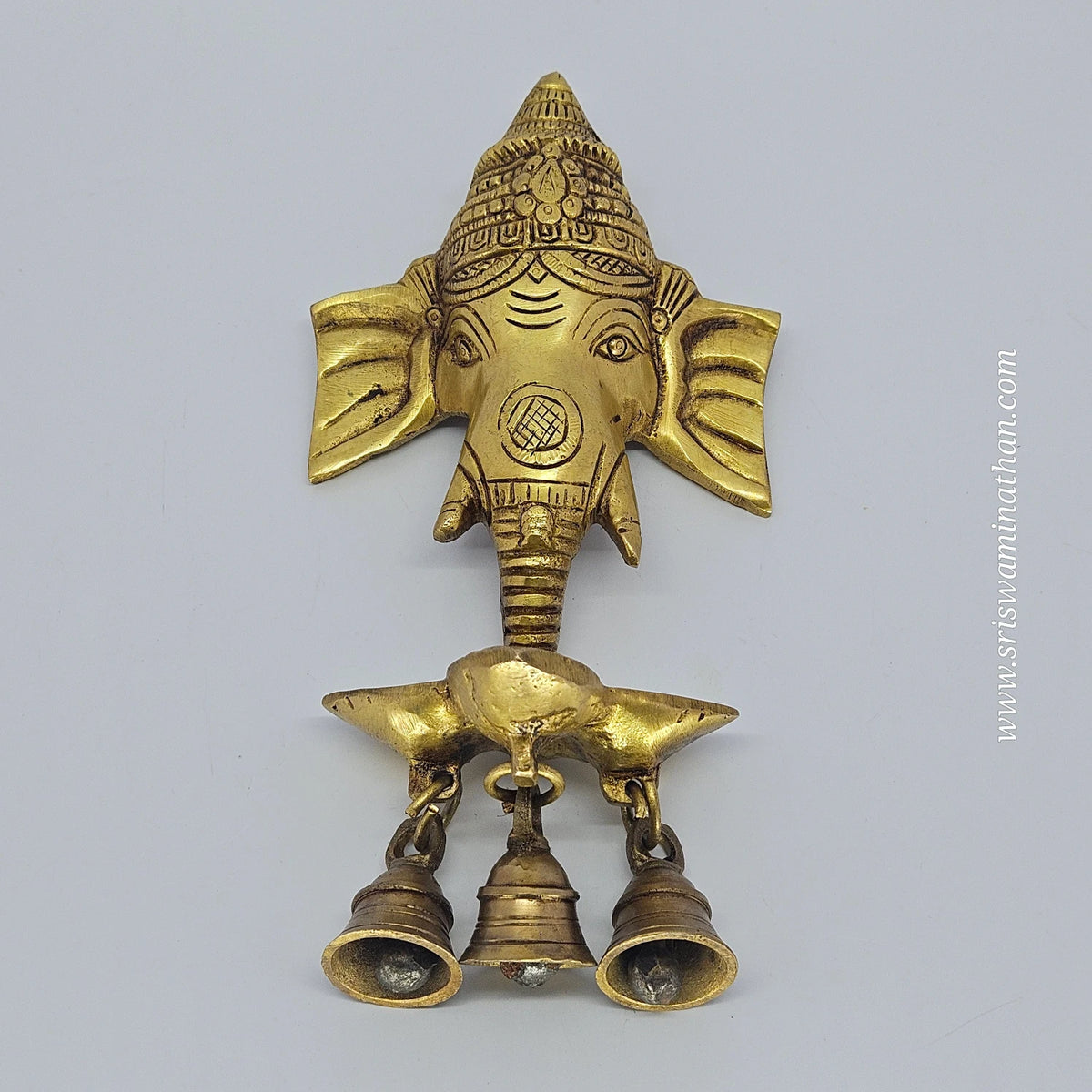 Straight flat front view showing the real shape of the 21cm solid brass Ganesha wall hanging diya piece resting on a flat surface.
