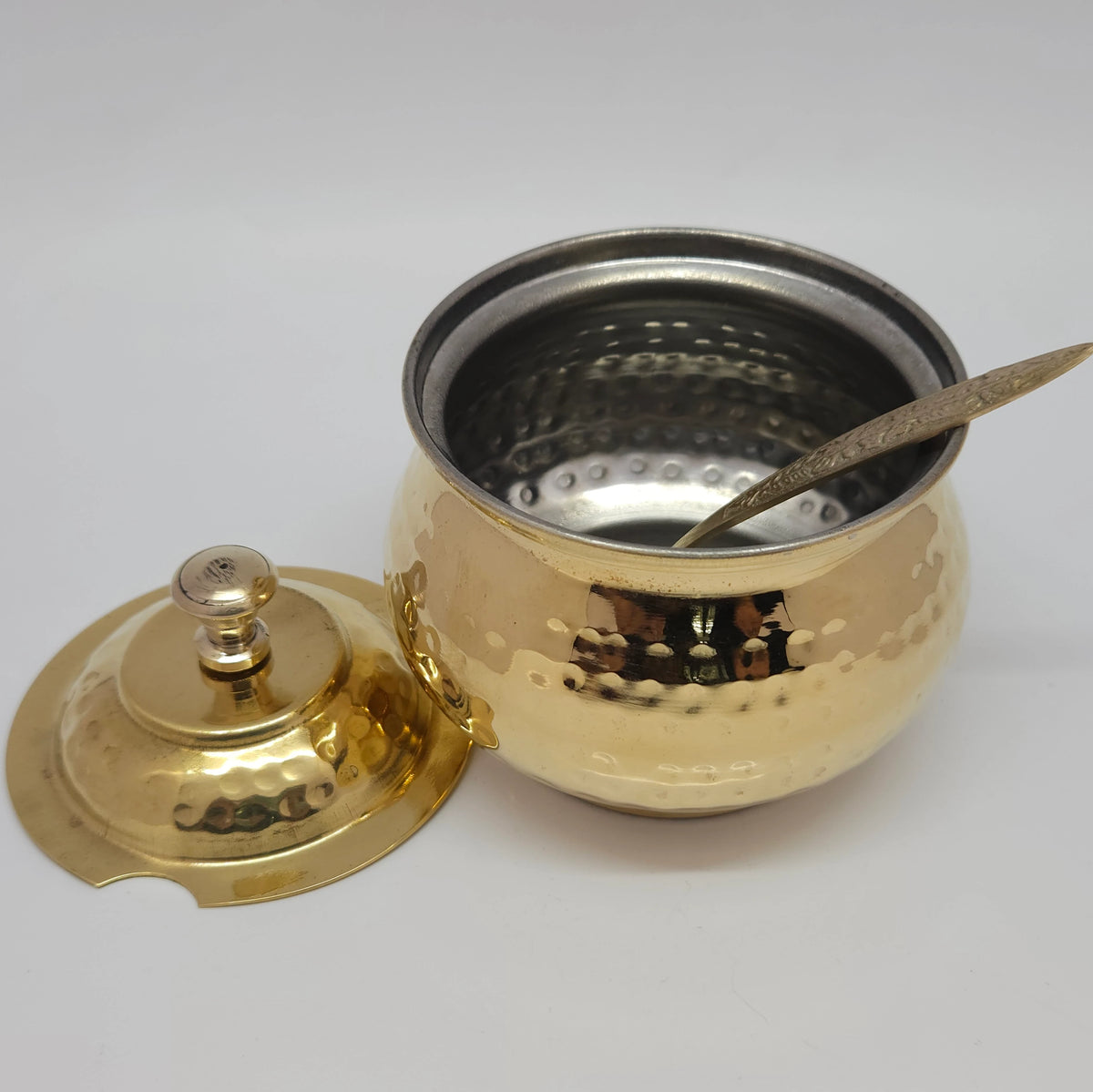Top down angle view looking directly into the open brass ghee pot showing the smooth protective food-safe inner tin lining layer