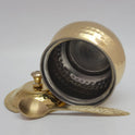 Tilted side perspective view of the glossy hammered brass ghee pot showcasing the contrasting interior silver-colored tin coating safety layer