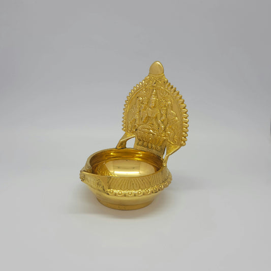 Three-quarter front left perspective view of the solid brass Kubera Gajalakshmi lamp showing the sharp vertical ridge lines on the outer rim.