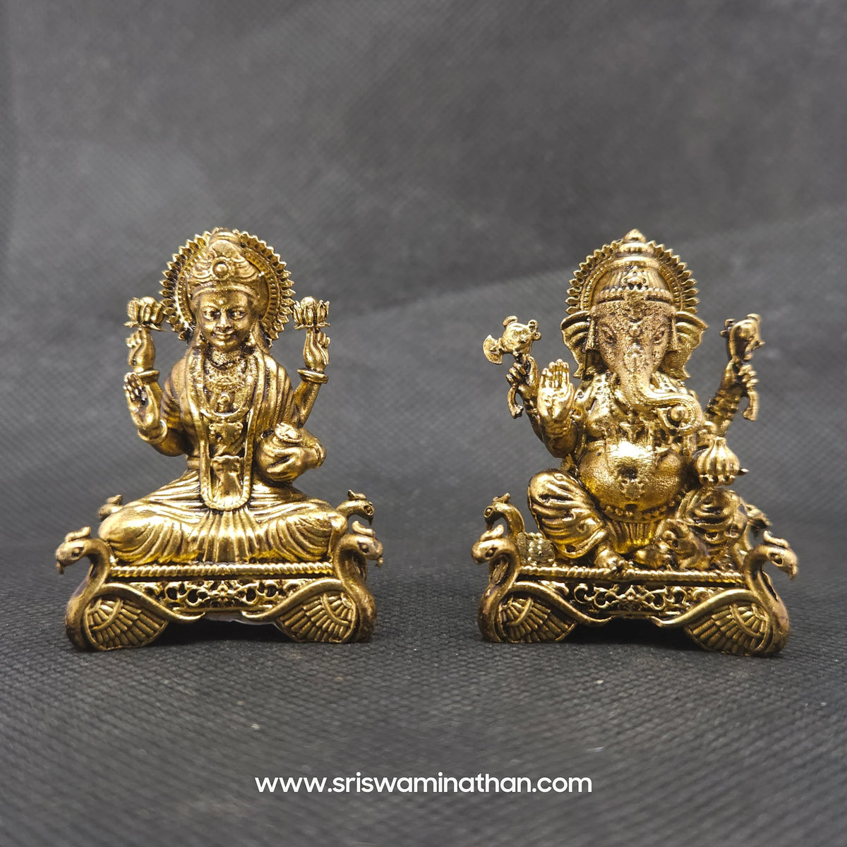 Front perspective view showcasing a paired set of the brass seated Lakshmi statue alongside a matching seated Ganesha idol on a matching hamsa throne base.