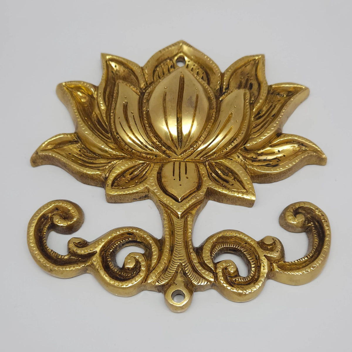  Three-quarter front perspective view of the brass lotus medallion wall decor highlighting the detailed chiseled petal layers and scrollwork base.
