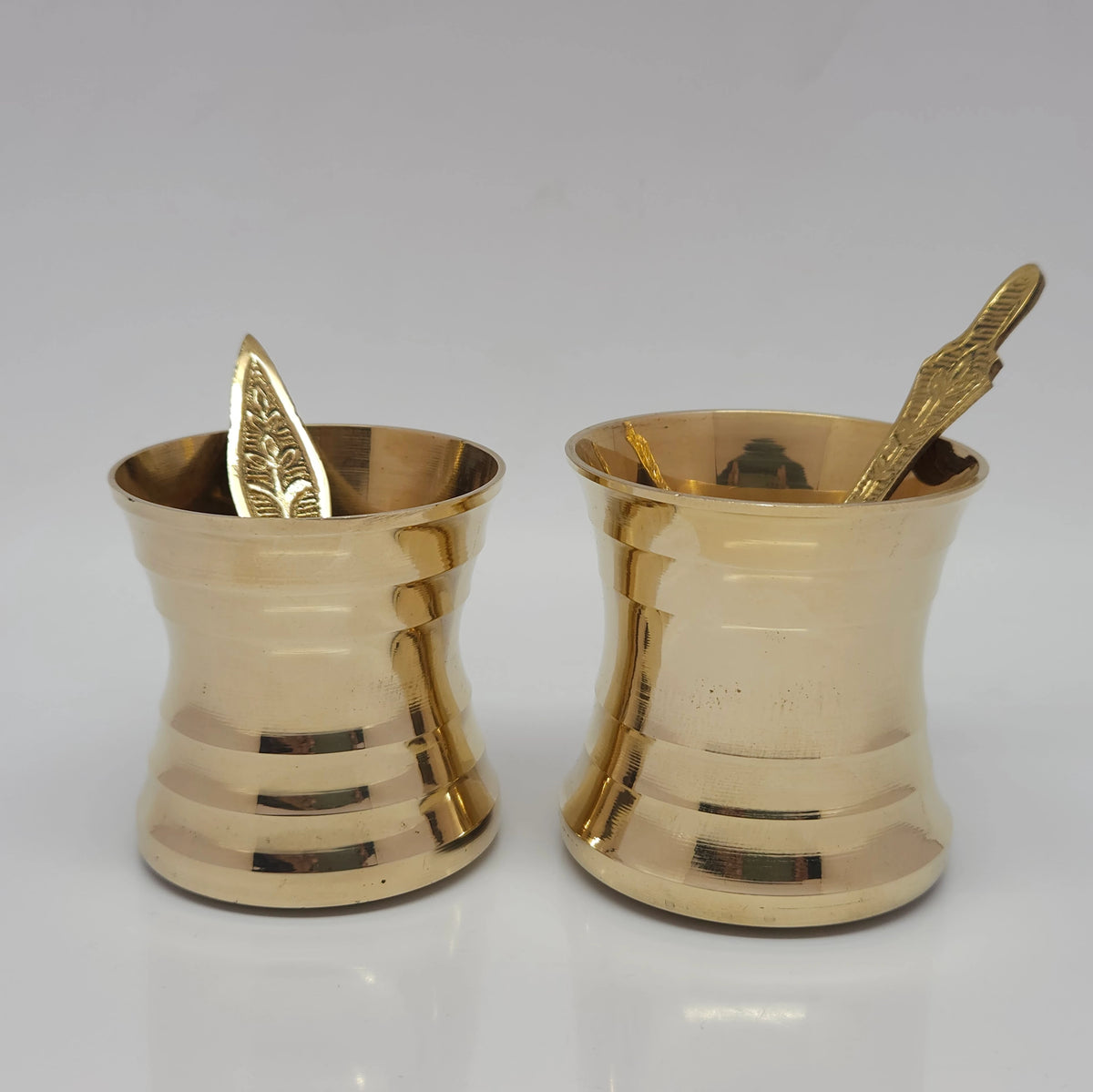 Straight front view comparing the small and big size variants of the pure brass panchapatram with uthirani to showcase the distinct horizontal ring layers