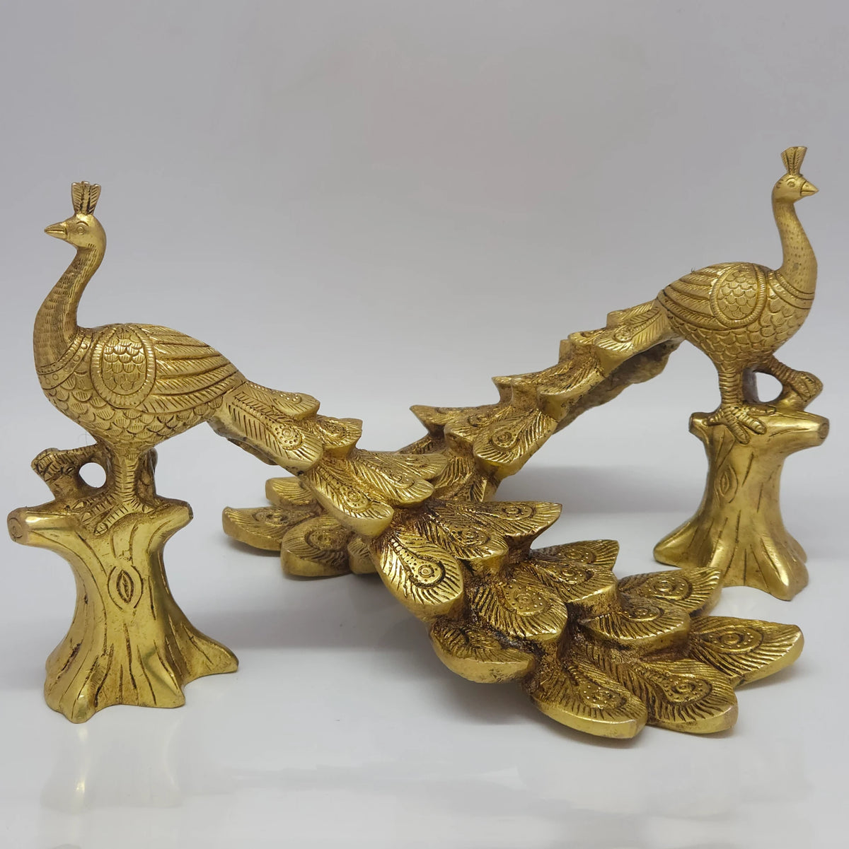 Three-quarter rear perspective view demonstrating the symmetry layout styling suggestion with two individual brass peacock statues facing away from each other