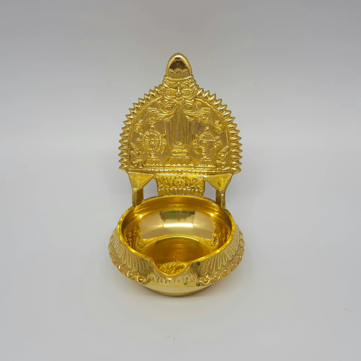 A 45-degree aerial top view of the 15cm brass Perumal Namam lamp clearly displaying the deep 150ml capacity oil basin and single wick nose by Sri Swaminathan and Co.