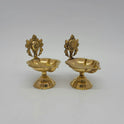 Three-quarter front left perspective view of the solid brass Shanku Chakra pedestal lamp pair showcasing the scalloped bowl rims